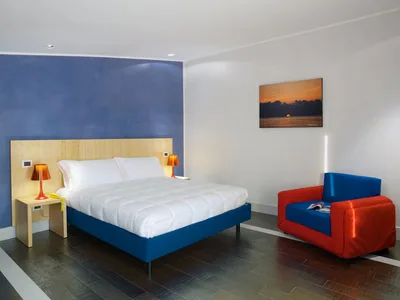 Una camera dell’Hotel Intervallo con letto matrimoniale e poltrona